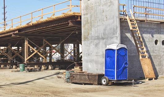 a row of modern porta potties at a busy work site, designed for easy use and maintenance